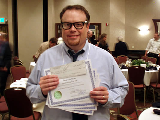 Holding a fist full of awards.